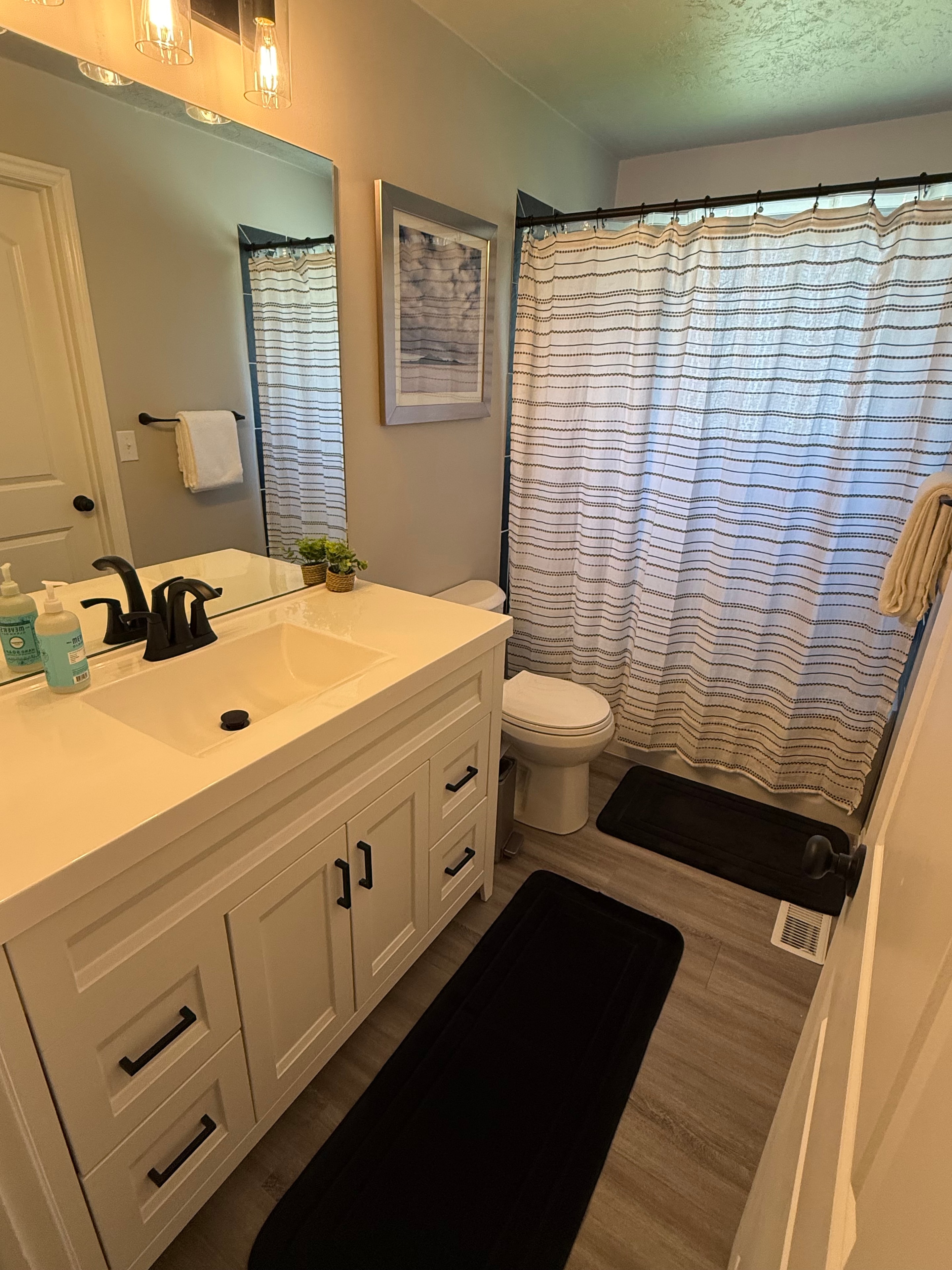 Bathroom with black marble tile and white vanity