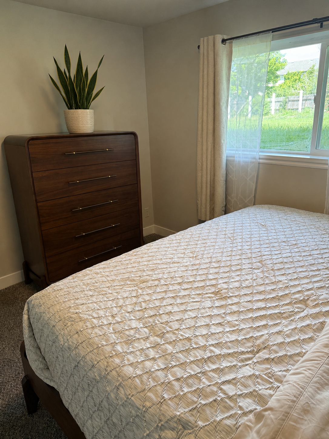 Bedroom with wood dresser and natural light