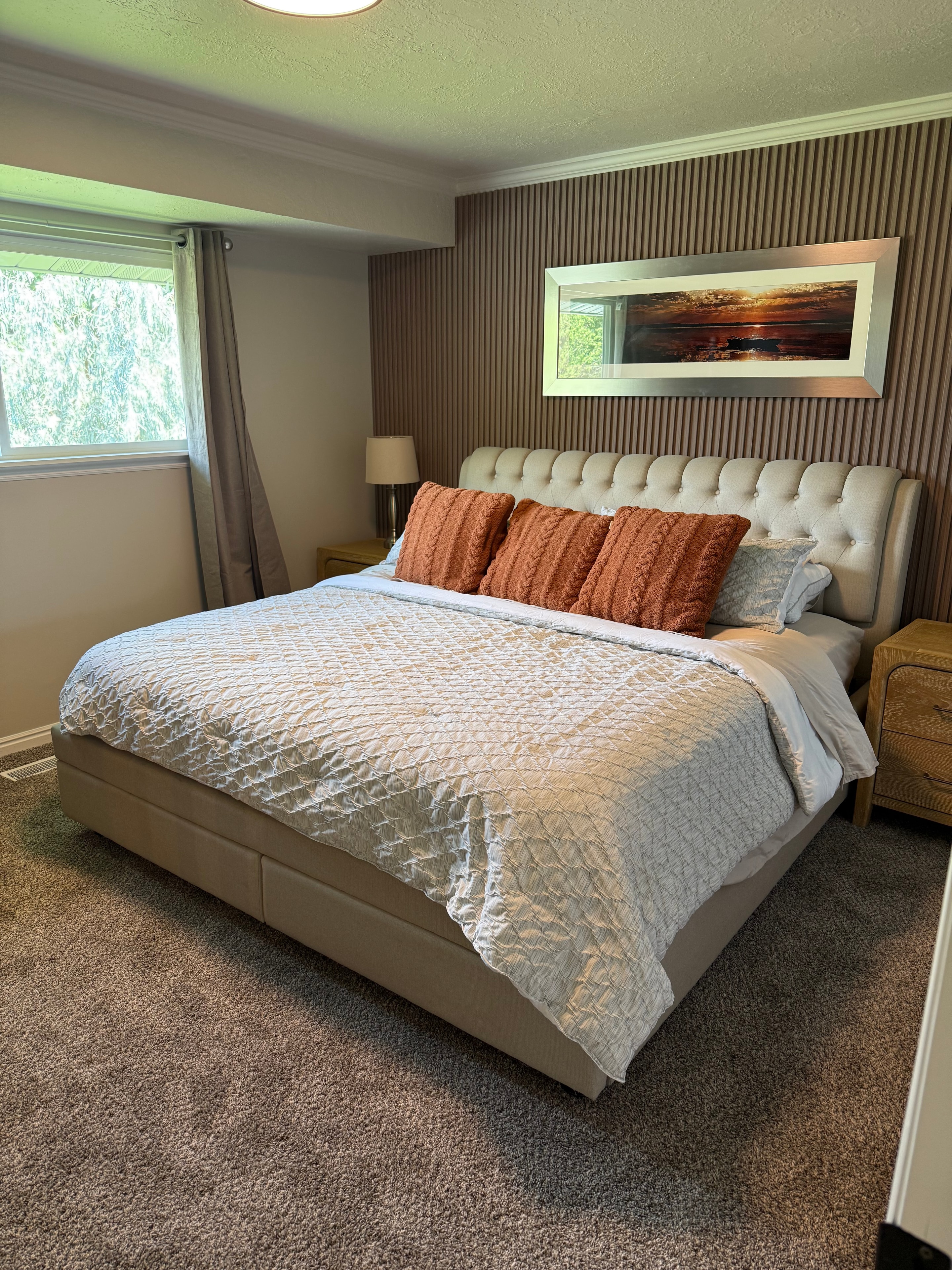 Master bedroom with tufted headboard and accent pillows