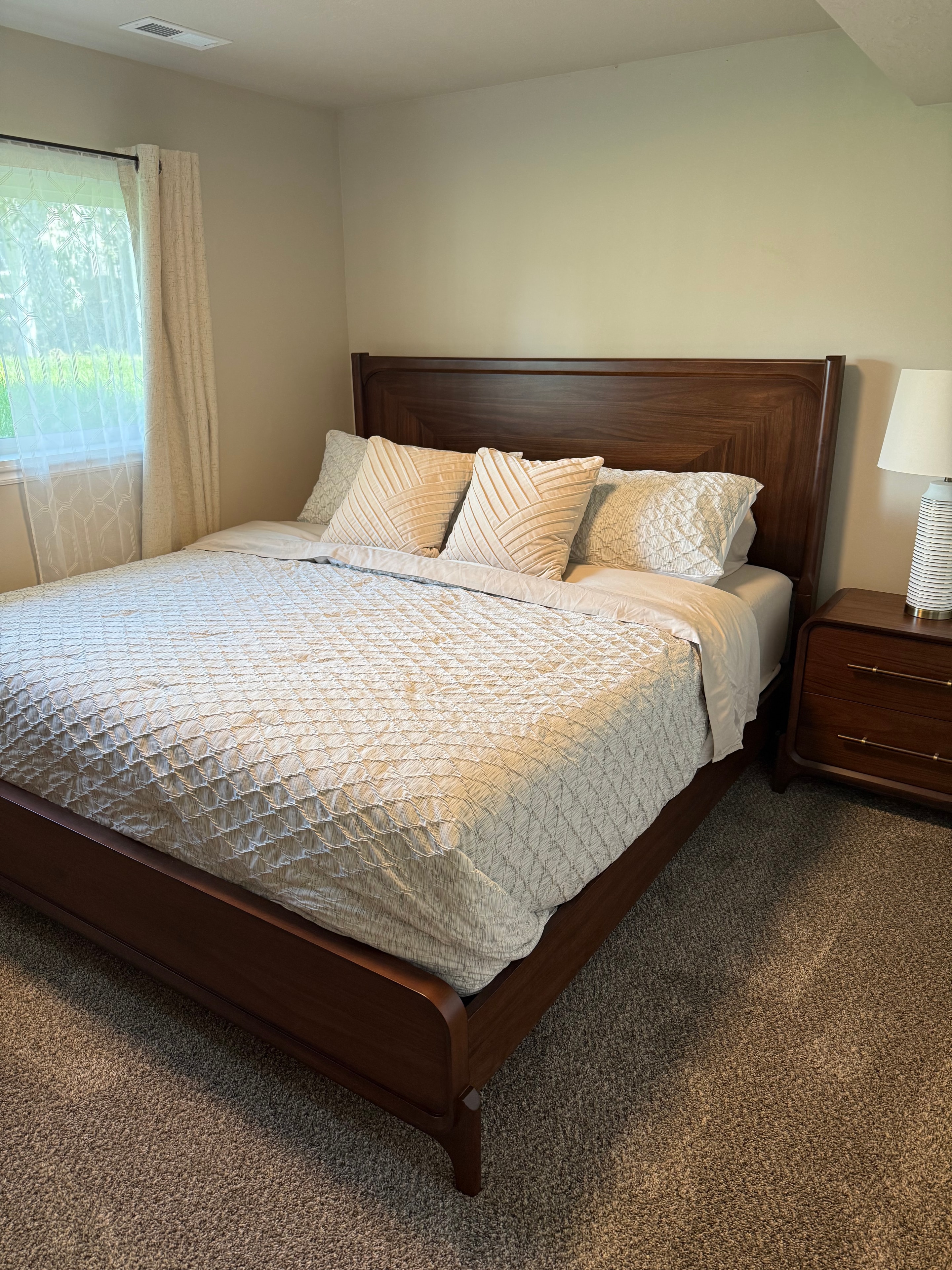 Bedroom with dark wood furniture and neutral bedding