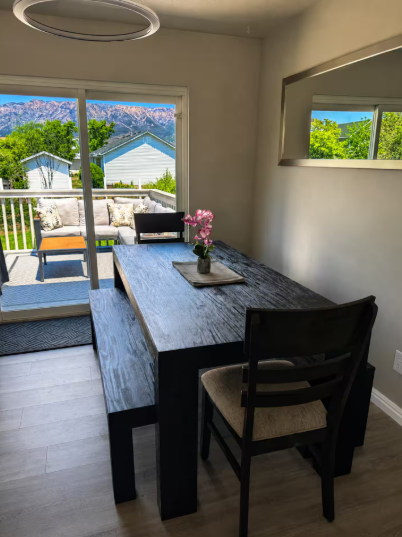 Dining area with dark wood table, bench seating, and mountain views