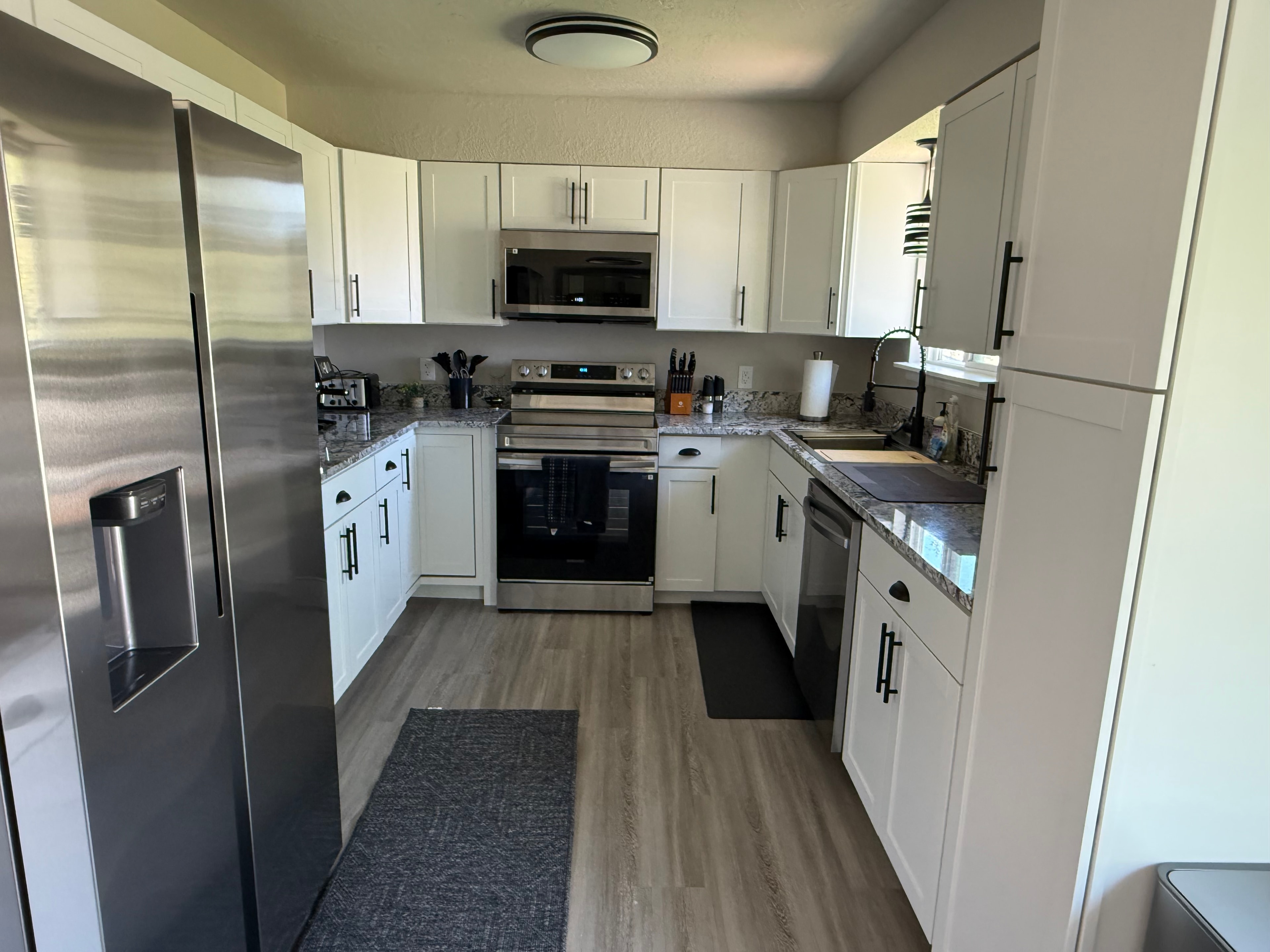 Fully equipped kitchen with white cabinets and stainless appliances