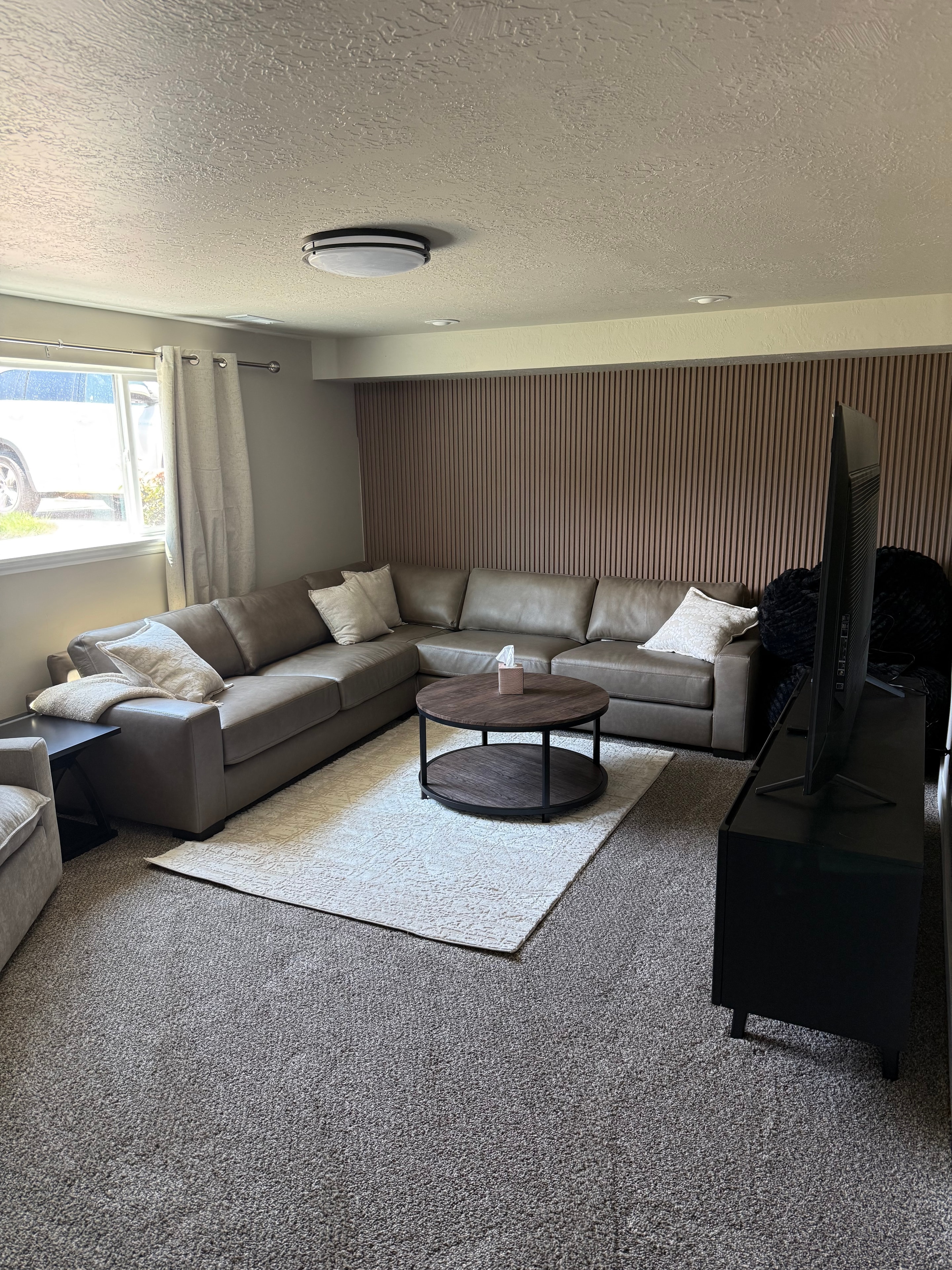Second living area with leather sofas and wood accent wall
