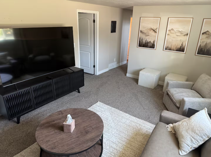 Living room with large TV, media console, and mountain artwork