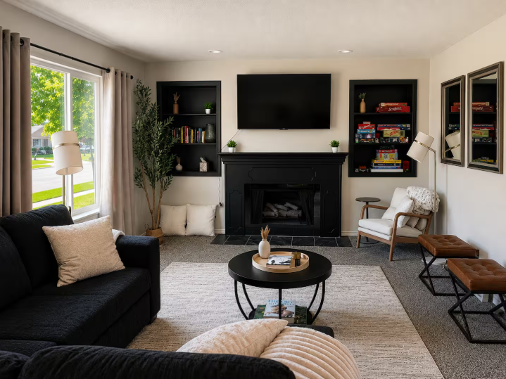 Main living room with black fireplace, built-in shelves, and board games