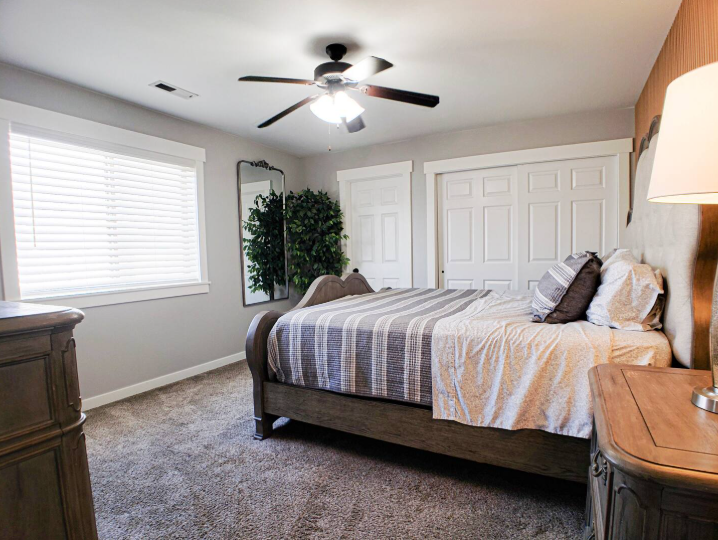 Bright bedroom with king bed, ceiling fan, double closets and large window