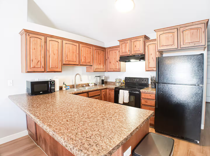 Fully equipped kitchen with knotty alder cabinets, granite countertops and black appliances