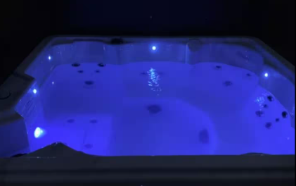 Private hot tub glowing with blue LED lights at night