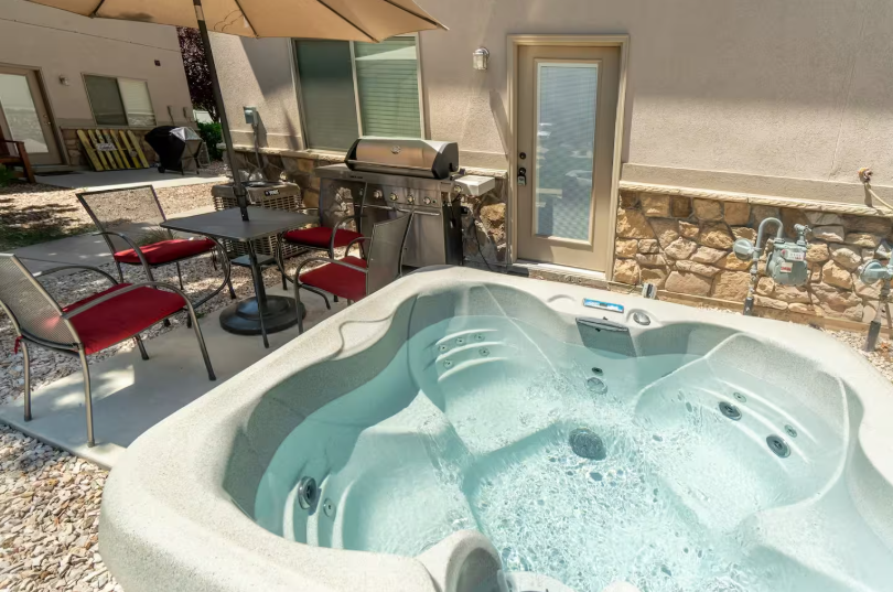 Private patio with hot tub, BBQ grill and outdoor dining set