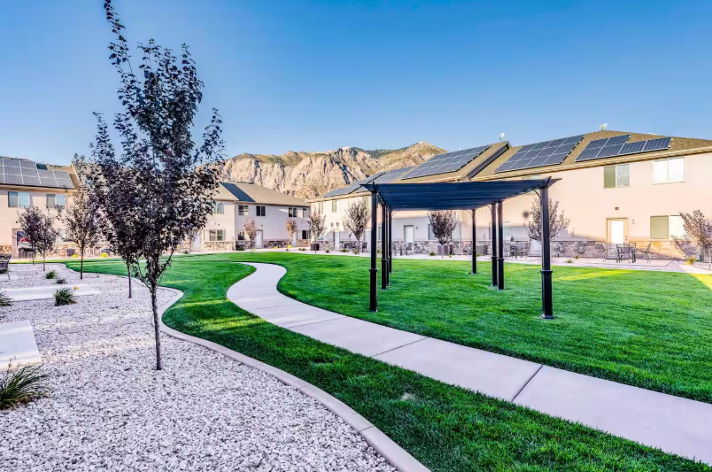 Beautifully landscaped community grounds with pergola and mountain views