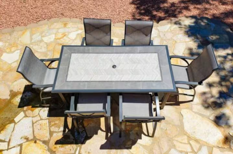 Outdoor stone patio with dining table and six chairs
