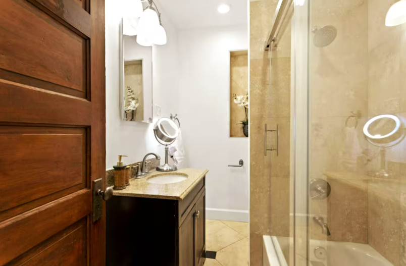 Spa-style bathroom with wood vanity, granite countertop, and glass shower