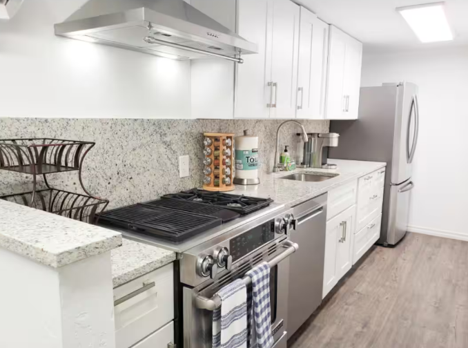 Kitchen with dark wood cabinetry, granite countertops, and stainless appliances