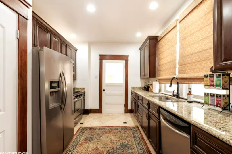 Modern white kitchen with granite countertops and stainless steel appliances