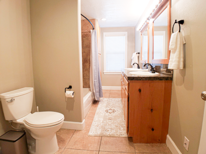 Full bathroom with wood vanity, tub-shower combo, and tile floors
