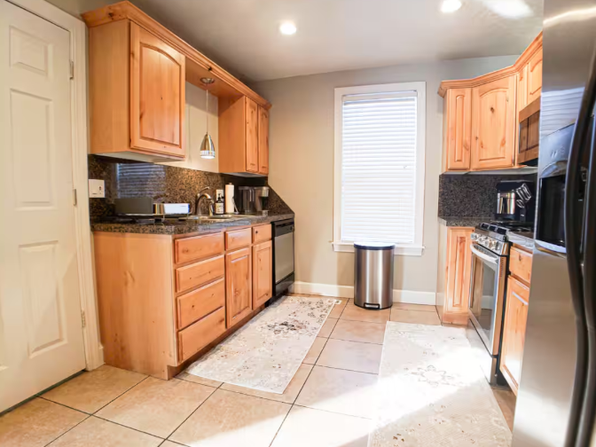 Kitchen with knotty alder cabinets, dark granite countertops, and stainless steel appliances