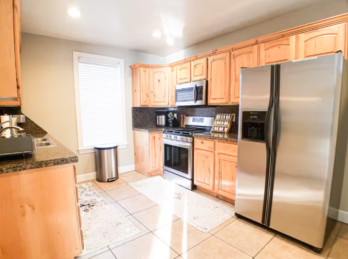 Kitchen with knotty alder cabinets, stainless steel refrigerator, and gas range