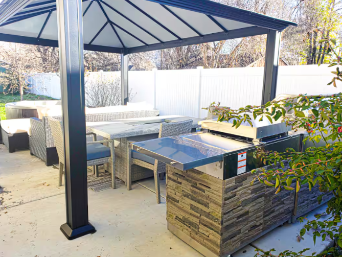 Covered pergola patio with wicker dining set and outdoor grill station
