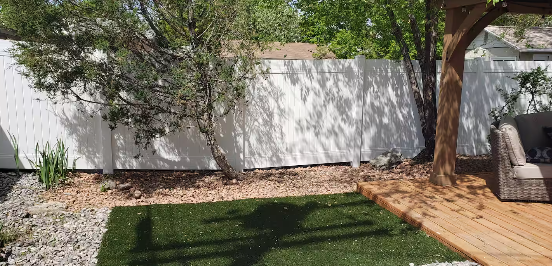 Fenced backyard with turf lawn and deck