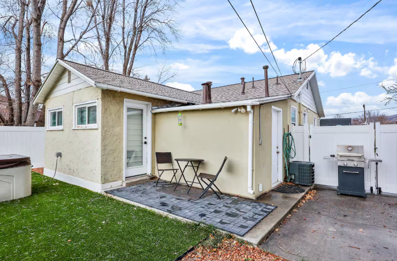 Backyard patio with turf lawn and gas grill