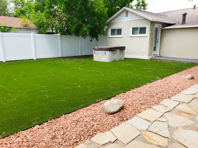 Fenced backyard with turf lawn, hot tub and stone pathway