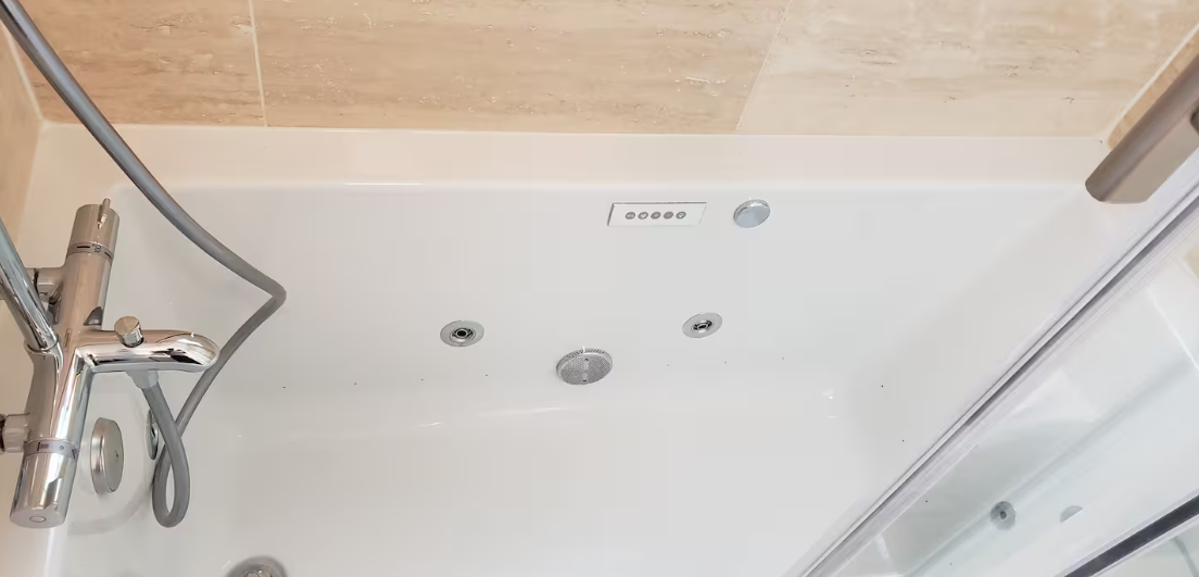 Jetted tub interior with chrome fixtures and tile surround